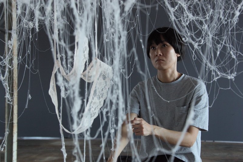 Künstlerin Kaoru Hirano aus Japan richtet eine Installation aus einem zu Fäden aufgelösten Kleid ein. Foto: LWL/Holtappels Foto freundlicherweise vom Museum zur Verfügung gestellt