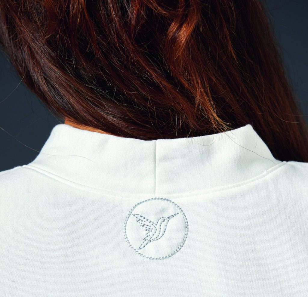 The back of the neck from the free sewing pattern features a humminbird embroidery design, which is emproidered in a grey thread just below the center of the back neckline.