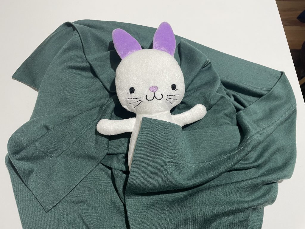 green receiving blanket with bunny plushie