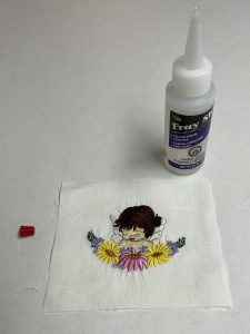 Adding anti fray product to the edge of an embroidery design